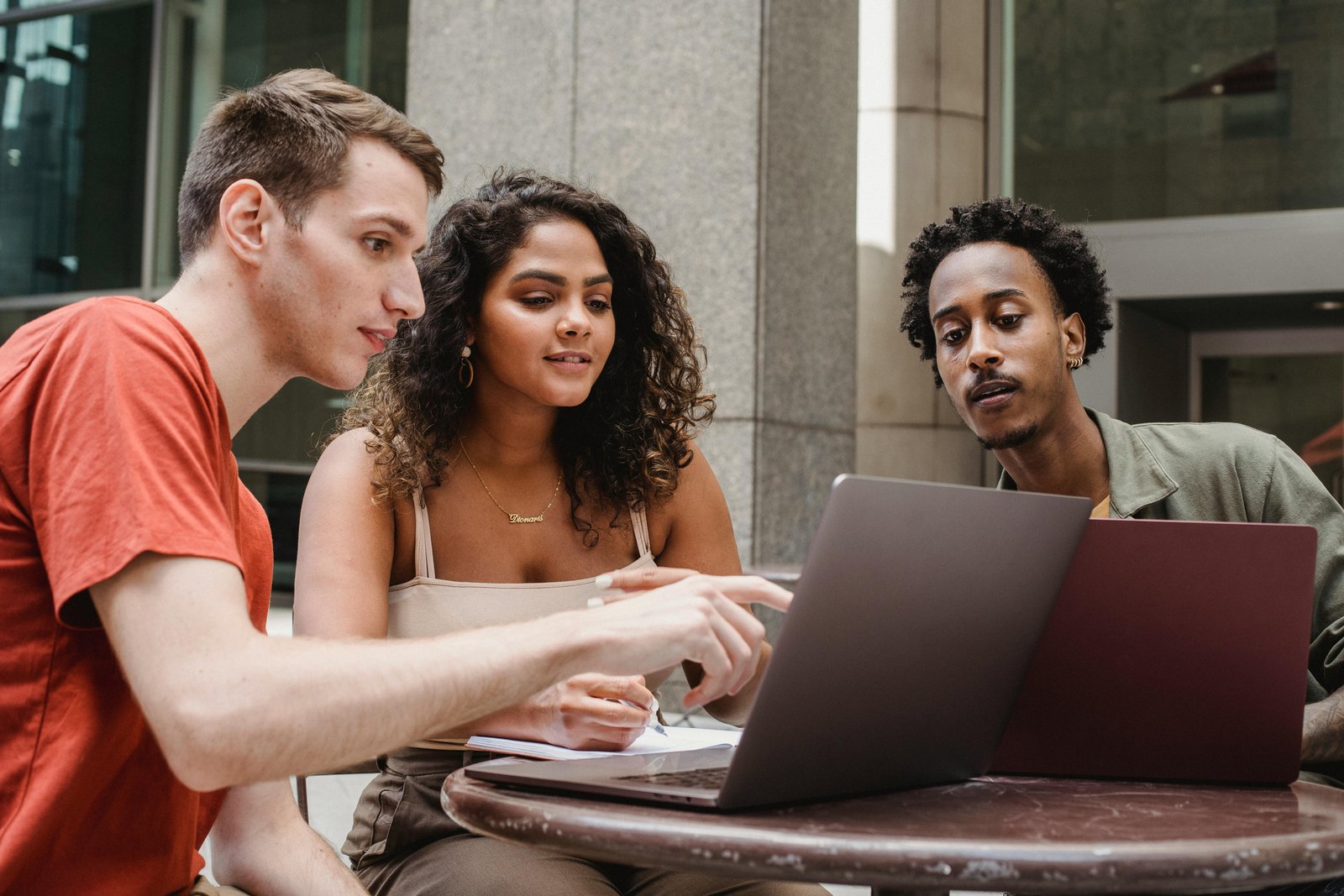 Three adult students around a computer